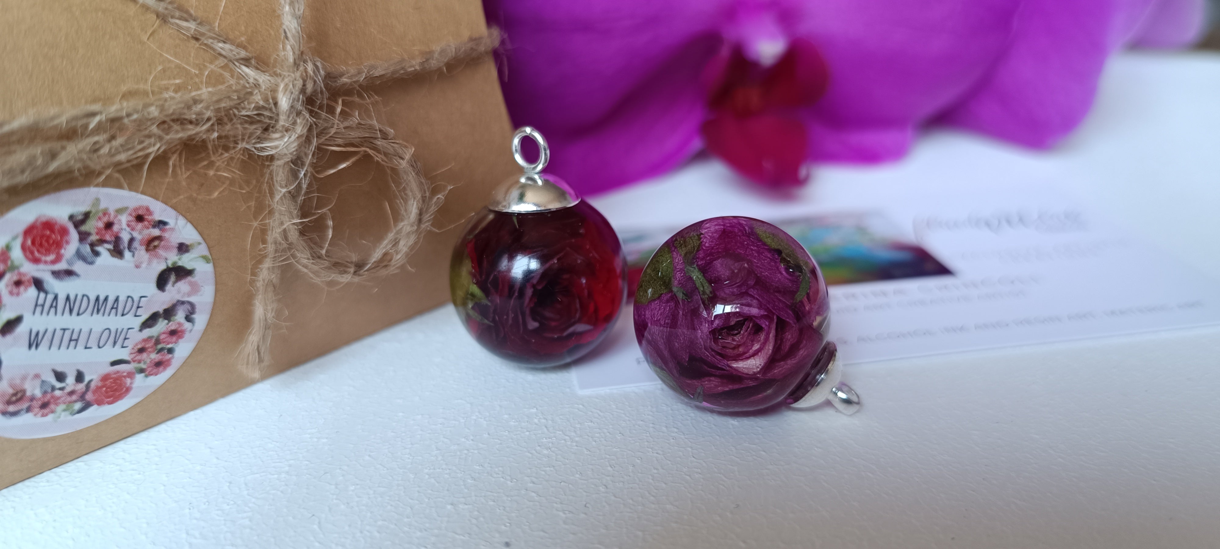 due ciondoli a sfera con rose visti da vicino